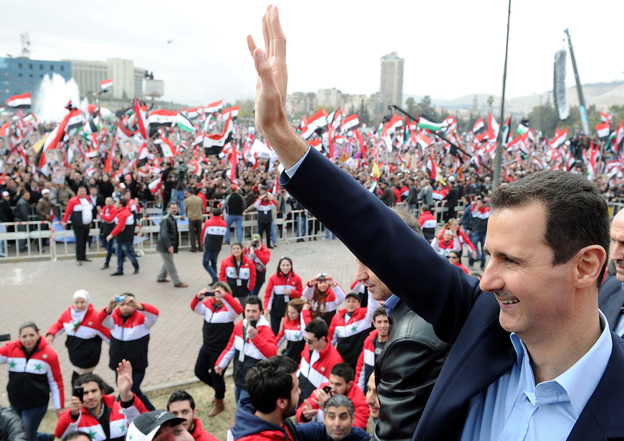 Syrian President Bashar Assad waves at supporters during a rare public appearance in Damascus on Jan. 11.