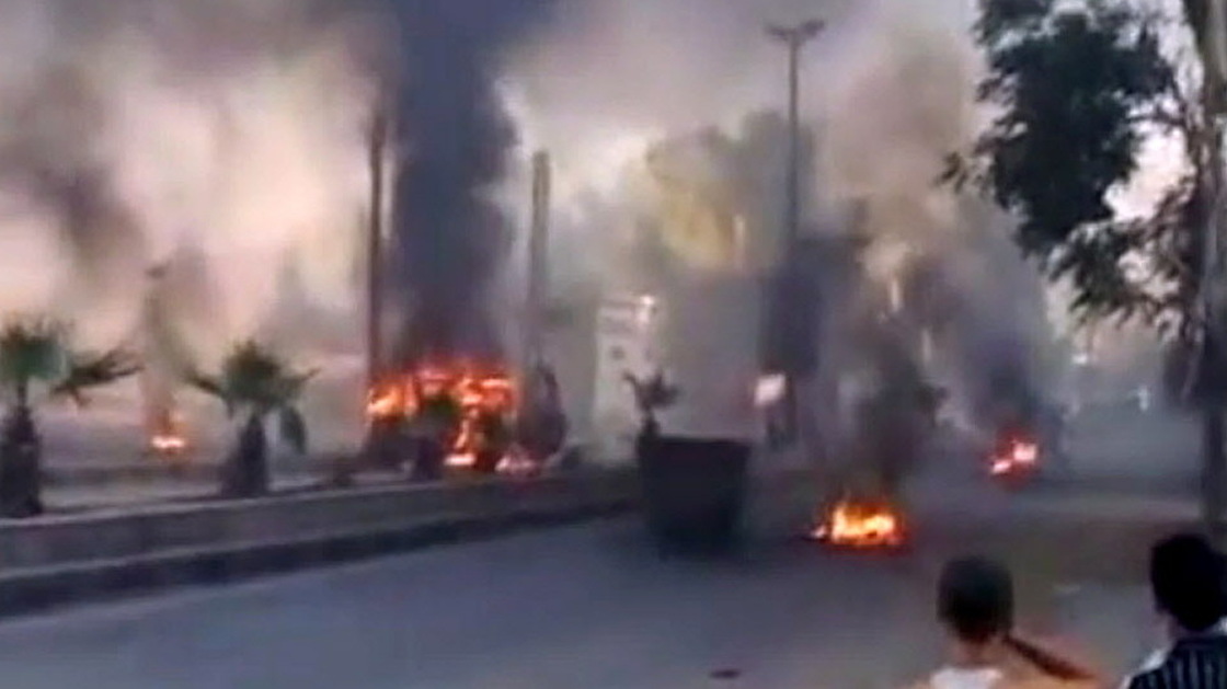 An image grab taken from a video uploaded on YouTube on Wednesday shows smoke billowing from burning tires and trash containers in Damascus.