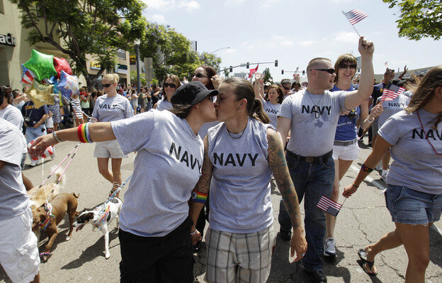 In this July 16, 2011 photo, two women, both active duty sailors in the Navy who gave their names as Nikki, left, and Lisa, kiss as they march in the Gay Pride Parade in San Diego.