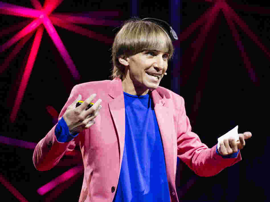 "Sonochromatic cyborg" and artist Neil Harbisson — with the implanted device that converts color to sound — at his TED talk in Edinburgh last month.