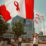 Kim Gerlach of Vancouver waves the flag designed by Affirmative Aids Action for the XI International Conference on AIDS, July 1996.