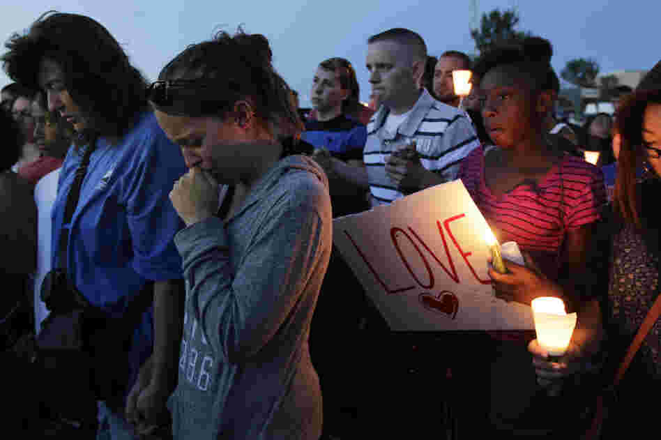Crowds gathered to honor the victims of the attack Friday in Aurora. Witnesses said the shooter came into the theater dressed in black after the film had already started.