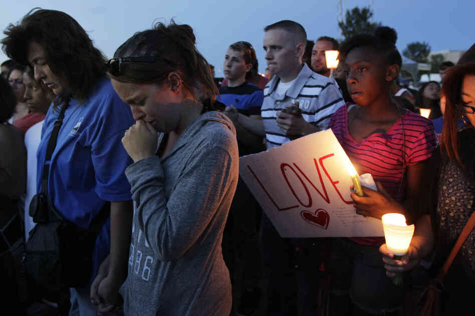 Crowds gathered to honor the victims of the attack Friday in Aurora. Witnesses said the shooter came into the theater dressed in black after the film had already started.