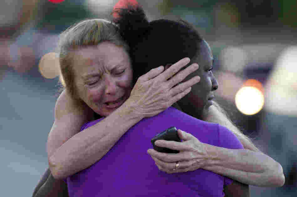 Two women mourn near the Century 16 theater Friday.