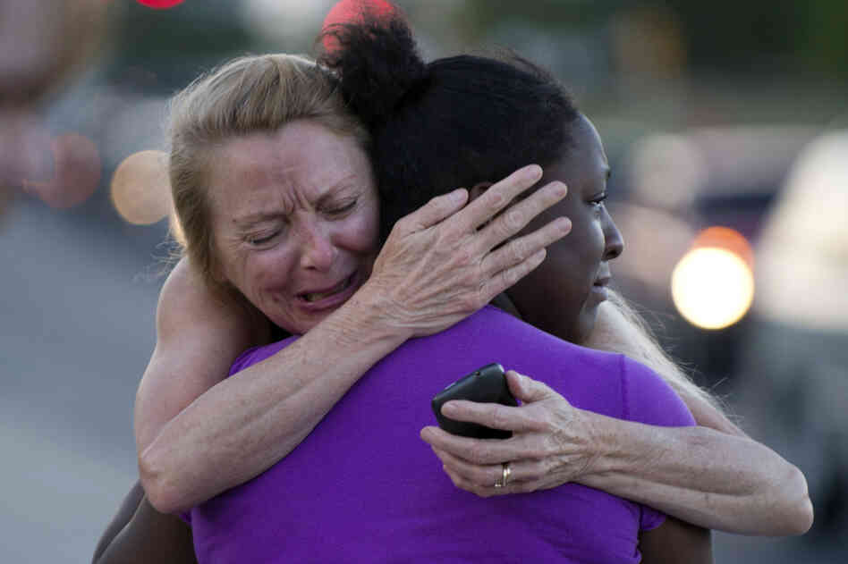 Two women mourn near the Century 16 theater Friday.