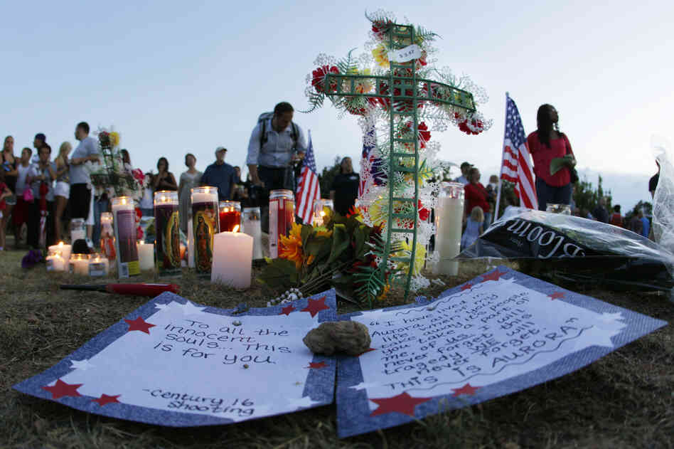 A written message that begins "To all the innocent souls ... this is for you," is shown near other tributes Friday in Aurora.