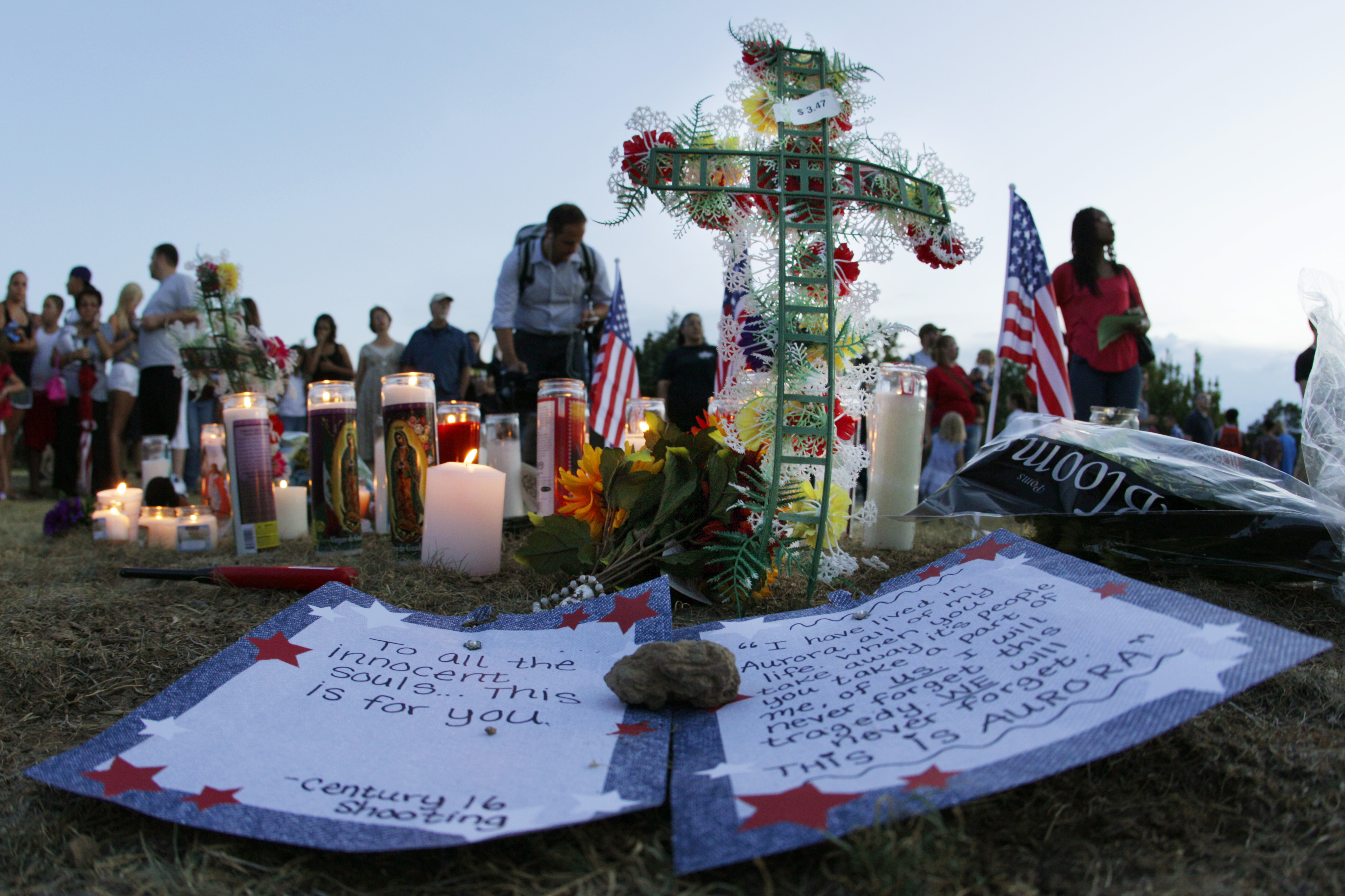 A written message that begins "To all the innocent souls ... this is for you," is shown near other tributes Friday in Aurora.