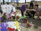 Pastor Mary Lu Saddoris (left) prays with Isaac Pacheo (center) and Courtney McGregor near a photo of their friend Alex Sullivan on Saturday at a memorial near the movie theater in Aurora, Colo. Pastor Mary Lu Saddoris (left) prays with Isaac Pacheo (center) and Courtney McGregor near a photo of their friend Alex Sullivan on Saturday at a memorial near the movie theater in Aurora, Colo.