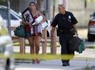 An Aurora police officer assists a woman carrying her belongings from her home near the apartment of alleged gunman James Holmes. Bomb technicians are working to defuse his booby-trapped apartment. An Aurora police officer assists a woman carrying her belongings from her home near the apartment of alleged gunman James Holmes. Bomb technicians are working to defuse his booby-trapped apartment.