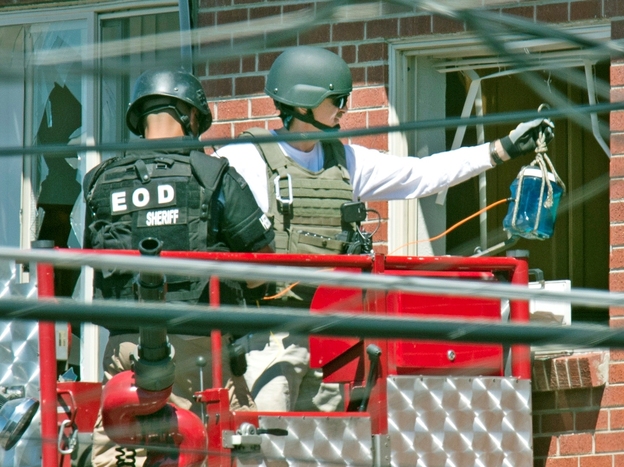 Bomb technicians used what one described to the Denver Post as a water bottle rigged with an explosive to destroy a "trip device" inside James Holmes' apartment.