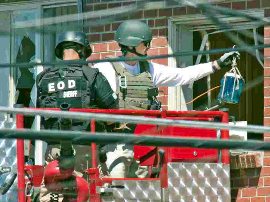 Bomb technicians used what one described to the Denver Post as a water bottle rigged with an explosive to destroy a "trip device" inside James Holmes' apartment.