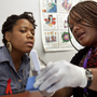 HIV counselor Natrussa Williams explains the results of the oral HIV test to Katherine Tapp at the D.C. Department of Motor Vehicles in southeast Washington. There have been no babies born with HIV in the city since 2009, in part because of increased testing at locations including some high schools and the DMV.