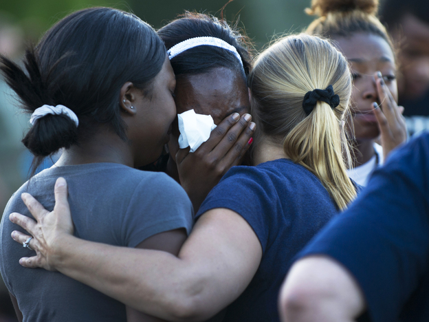 Mourners at a vigil Friday near the theater in Aurora, Colo., where 12 people were killed and about 58 wounded.