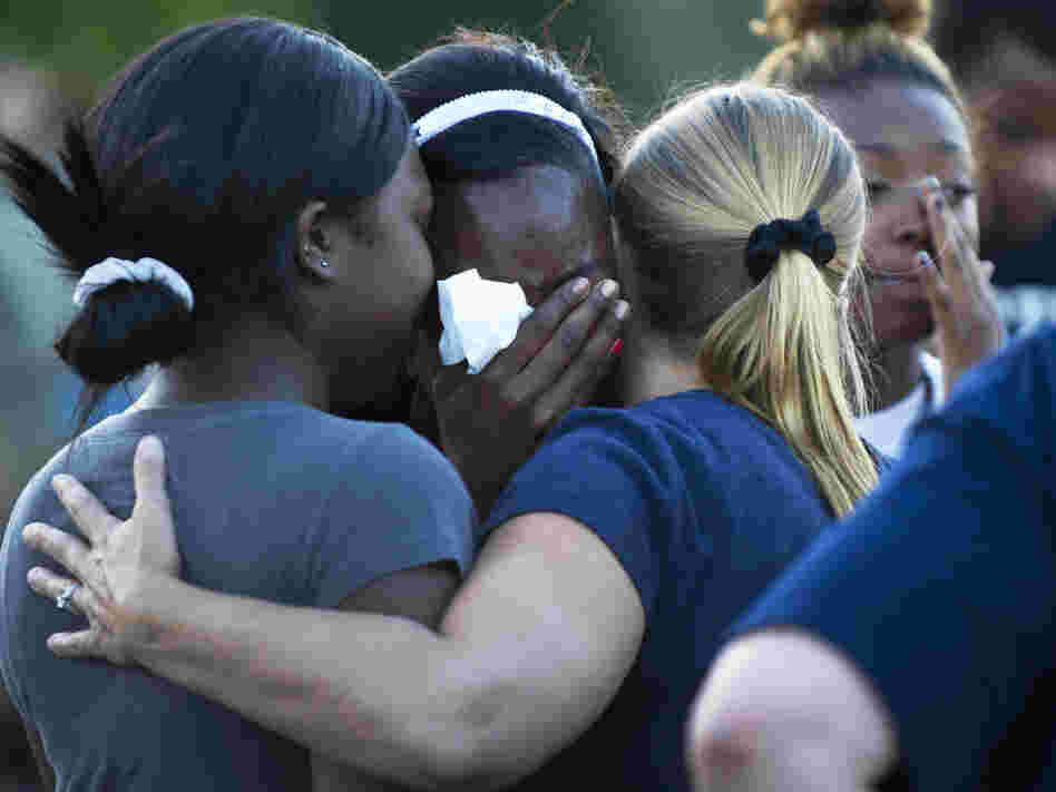 Mourners at a vigil Friday near the theater in Aurora, Colo., where 12 people were killed and about 58 wounded.