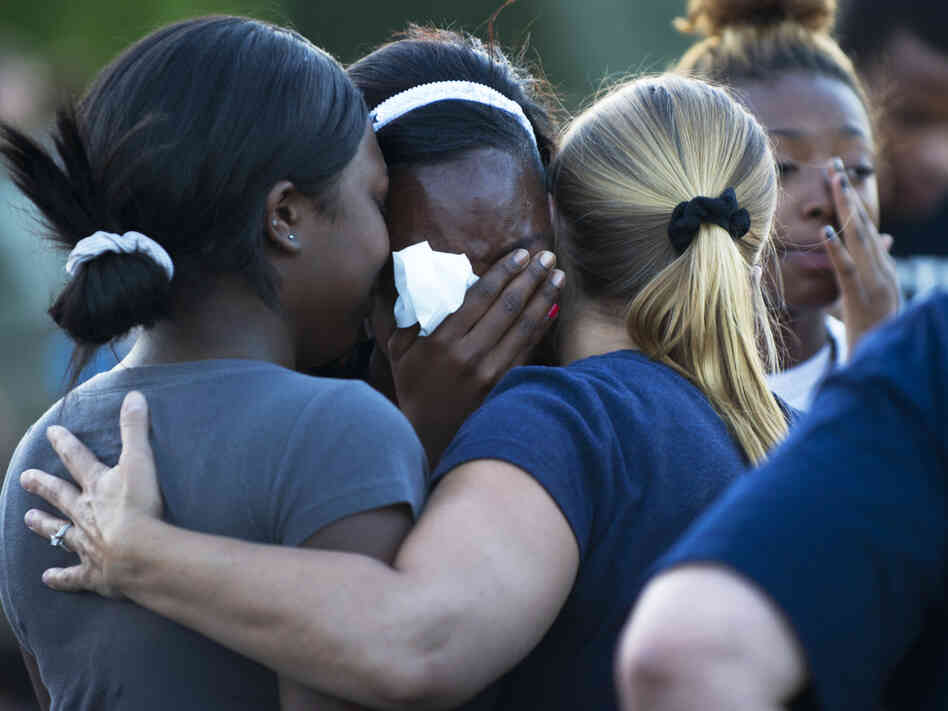 Mourners at a vigil Friday near the theater in Aurora, Colo., where 12 people were killed and about 58 wounded.