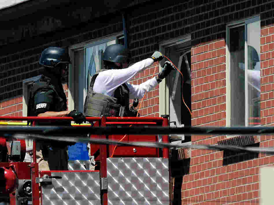 Law enforcement officers prepare to disarm the suspect's booby-trapped apartment Friday.