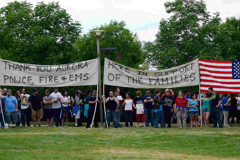 Members of the crowd create a human wall to block the Westboro Baptist Church from protesting the prayer vigil at the Aurora Municipal Center on Sunday.