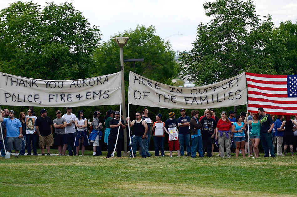 Members of the crowd create a human wall to block the Westboro Baptist Church from protesting the prayer vigil at the Aurora Municipal Center on Sunday.