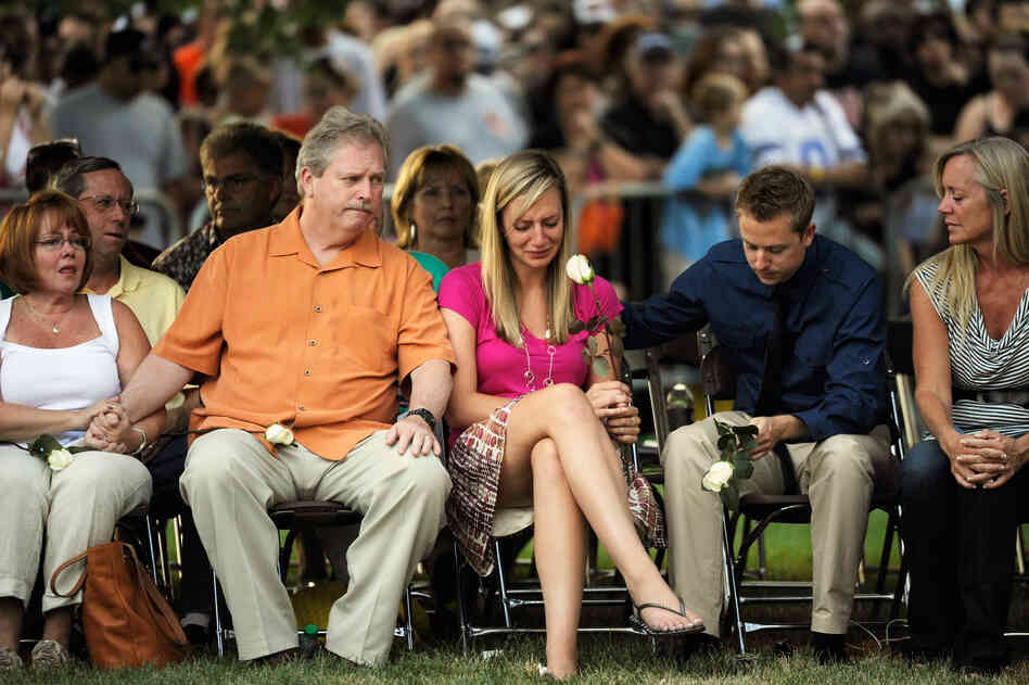 Mourners attend a vigil for the shooting victims Sunday in Aurora.