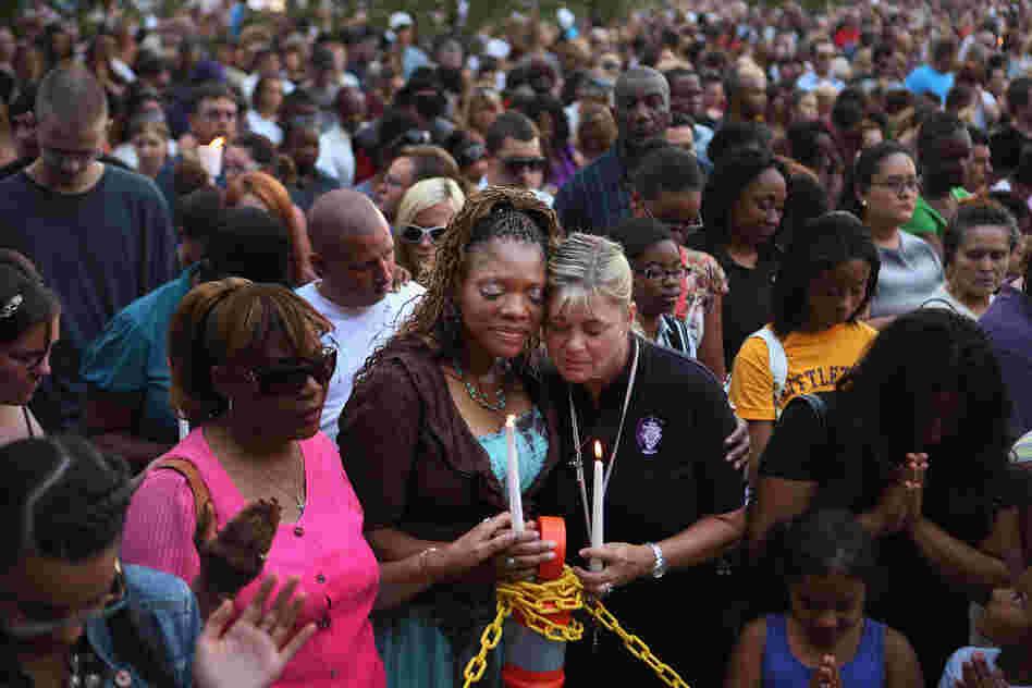 Titia Stillwell and Lori Meade embrace and pray with thousands of others during Sunday's vigil. 