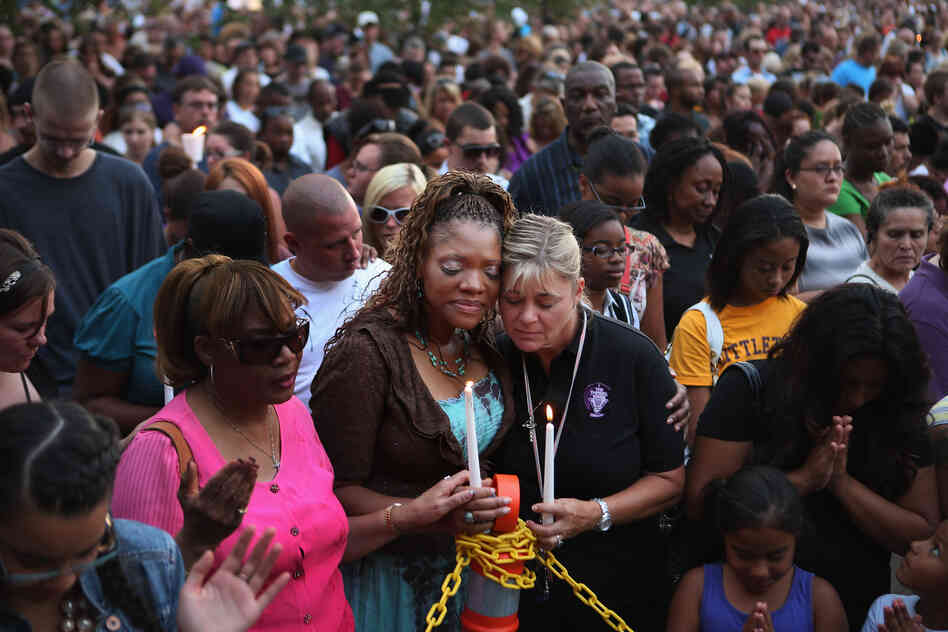 Titia Stillwell and Lori Meade embrace and pray with thousands of others during Sunday's vigil. 