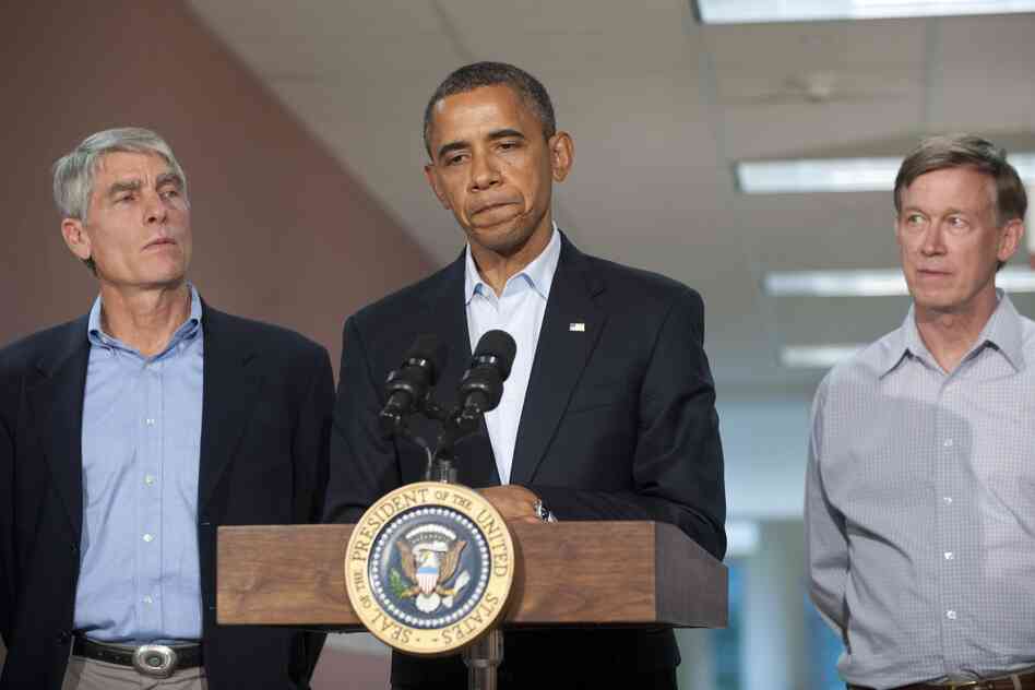 President Obama speaks alongside Colorado Sen. Mark Udall and Colorado Gov. John Hickenlooper (right) at the University of Colorado Hospital in Aurora on Sunday, following a visit with victims and family members.