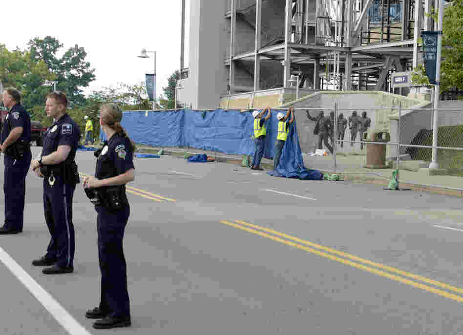 Police formed a line in front of Beaver Stadium as workers prepared to lifted the 7-foot-tall statue off its base and move it inside. 