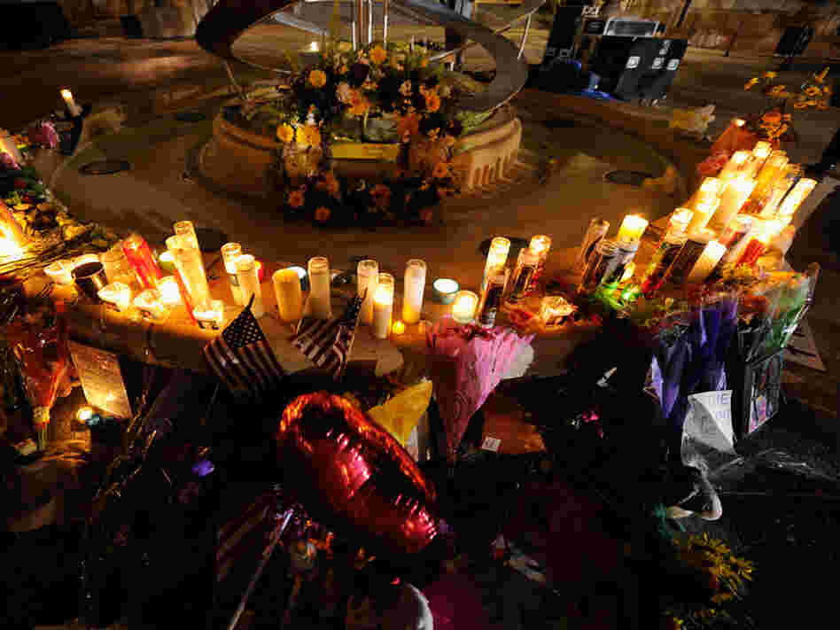 Mourners create a memorial at the fountain of the Aurora Municipal Center after a prayer vigil Sunday for the 12 victims of Friday's mass shooting at the Century 16 movie theater.