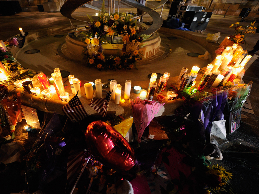 Mourners create a memorial at the fountain of the Aurora Municipal Center after a prayer vigil Sunday for the 12 victims of Friday's mass shooting at the Century 16 movie theater.