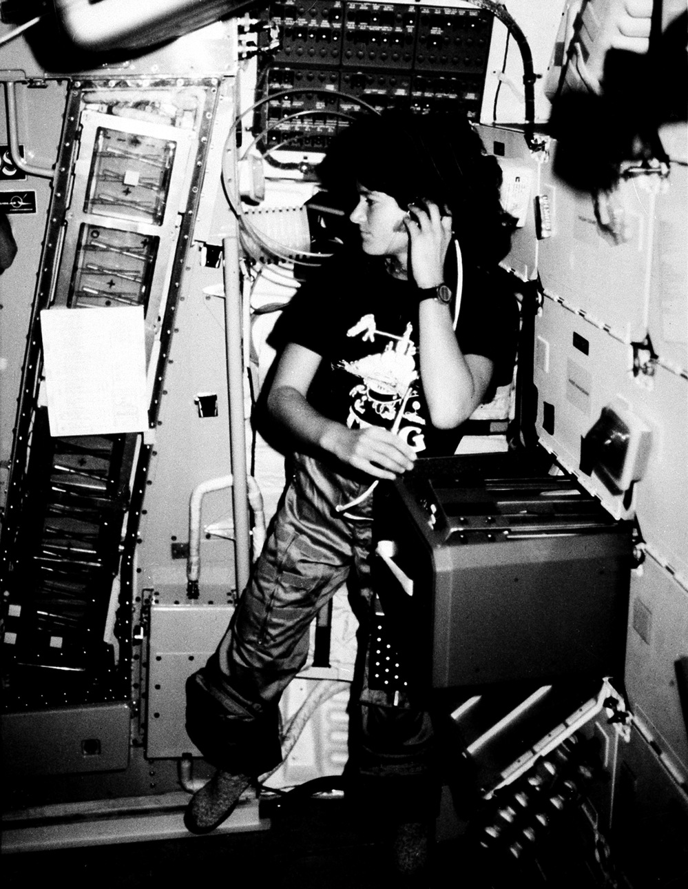 Astronaut Sally K. Ride, STS-7 mission specialist, communicates with ground controllers from the mid-deck of the earth-orbiting Space Shuttle Challenger in June 1983.