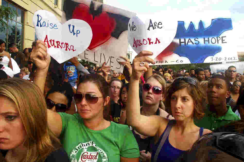 Many in the crowd at Sunday evening's memorial service, held outside of the Aurora Municipal Center, held up handmade signs honoring the shooting victims and the city of Aurora, Colo.