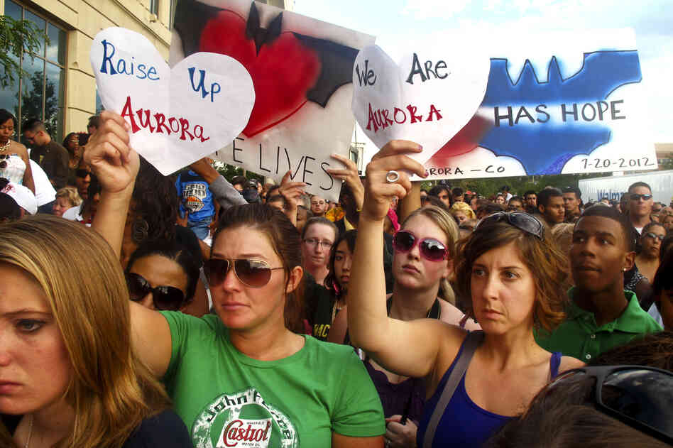 Many in the crowd at Sunday evening's memorial service, held outside of the Aurora Municipal Center, held up handmade signs honoring the shooting victims and the city of Aurora, Colo.
