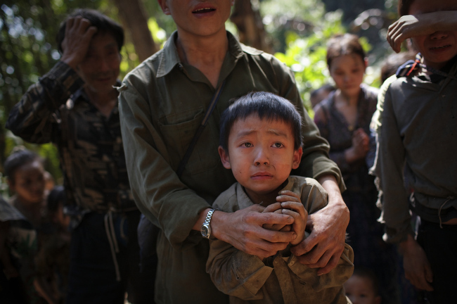Hmong villagers break down in tears at their hidden village in Laos, November 2007. The villagers are regular targets of the Lao People's Army for their roles in collaborating with the CIA during the Vietnam War. Their families have had limited contact with Westerners since 1975.