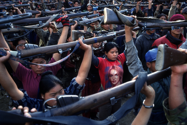 A Maoist rebel soldier in a Britney Spears T-shirt stands with soldiers of the People's Liberation Army during a drill in a schoolyard in the village of Gairigaon, Nepal, February 2005.