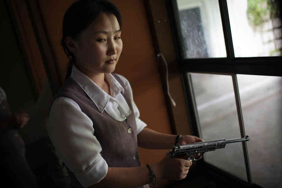 A North Korean woman loads a pistol for firing practice in Pyongyang, North Korea, August 2007.