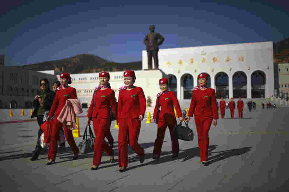 An all-girls group of Young Communist League members walks past a statue of Chairman Mao Zedong in Yan'an, China, November 2009. Yan'an is promoted as the "Revolutionary Holy Land" and offers a number of museums, monuments and other "Red Tourism" sites supported by the Chinese government.