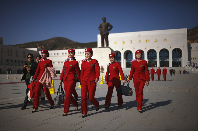 An all-girls group of Young Communist League members walks past a statue of Chairman Mao Zedong in Yan'an, China, November 2009. Yan'an is promoted as the 