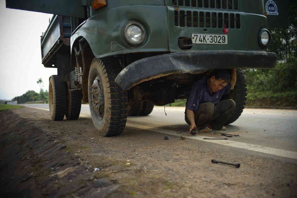 A truck driver repairs a broken Soviet truck along the Ho Chi Minh Highway inside the former demilitarized zone in Vietnam, February 2010.