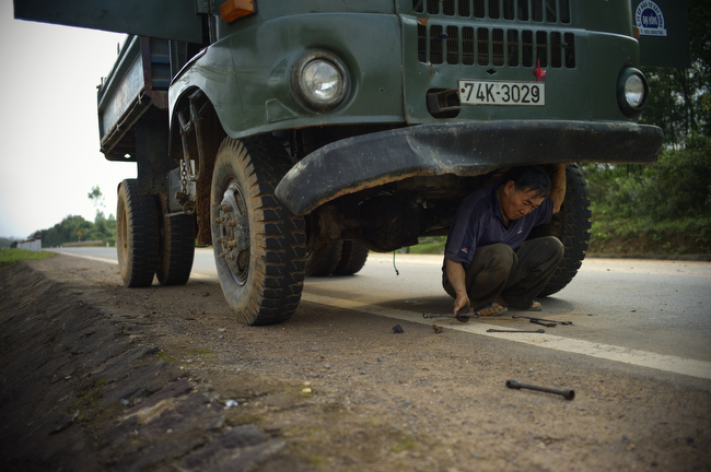 A truck driver repairs a broken Soviet truck along the Ho Chi Minh Highway inside the former demilitarized zone in Vietnam, February 2010.