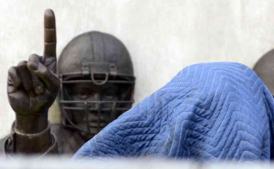 Before its removal from outside the school's football stadium on Sunday, a statue of former football coach Joe Paterno was covered. An independent report concluded he was among top university officials who failed to act when they learned that Jerry Sandusky might be sexually abusing young boys.