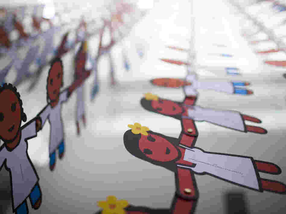 A paper doll chain with more than 25,000 cutouts hangs from the ceiling of the Washington, D.C. convention hall. Each doll displays a message about the power of female condoms to stop HIV. A paper doll chain with more than 25,000 cutouts hangs from the ceiling of the Washington, D.C. convention hall. Each doll displays a message about the power of female condoms to stop HIV.