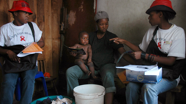 Health care workers in South Africa speak to residents during a door-to-door AIDS awareness campaign, part of a series of prevention efforts that has helped lower the country's HIV infection rate.