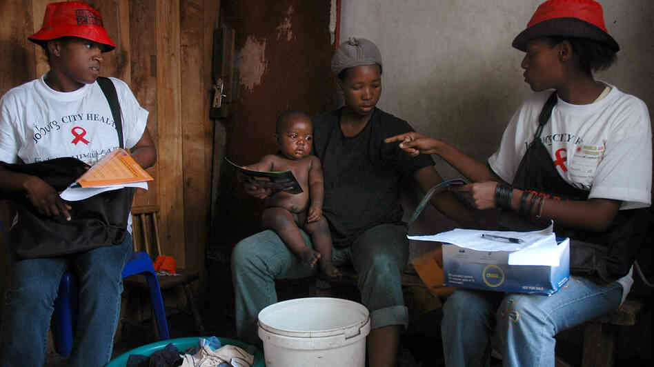 Health care workers in South Africa speak to residents during a door-to-door AIDS awareness campaign, part of a series of prevention efforts that has helped lower the country's HIV infection rate.