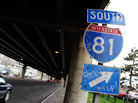 A sign for Interstate 81 sits under an overpass in Syracuse, N.Y. City officials and residents are debating what to do about an aging stretch of the highway that cuts through the city. A sign for Interstate 81 sits under an overpass in Syracuse, N.Y. City officials and residents are debating what to do about an aging stretch of the highway that cuts through the city.