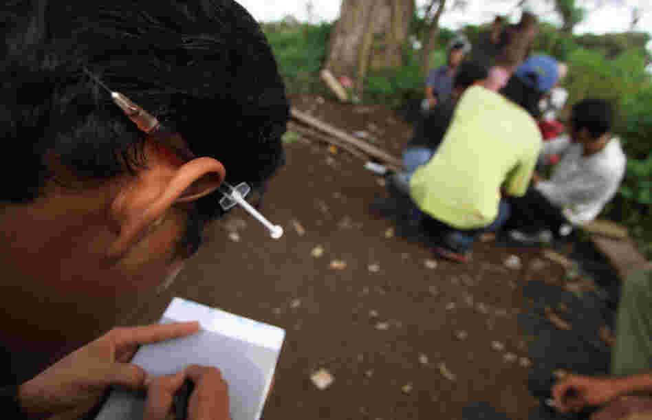 A heroin user keeps a syringe tucked behind his ear at a park in the city of Medan on Indonesia's Sumatra island. Cordita-Caritas Medan, a nongovernmental organization active there, works to reduce HIV infections through rehab of drug users and a needle exchange program.