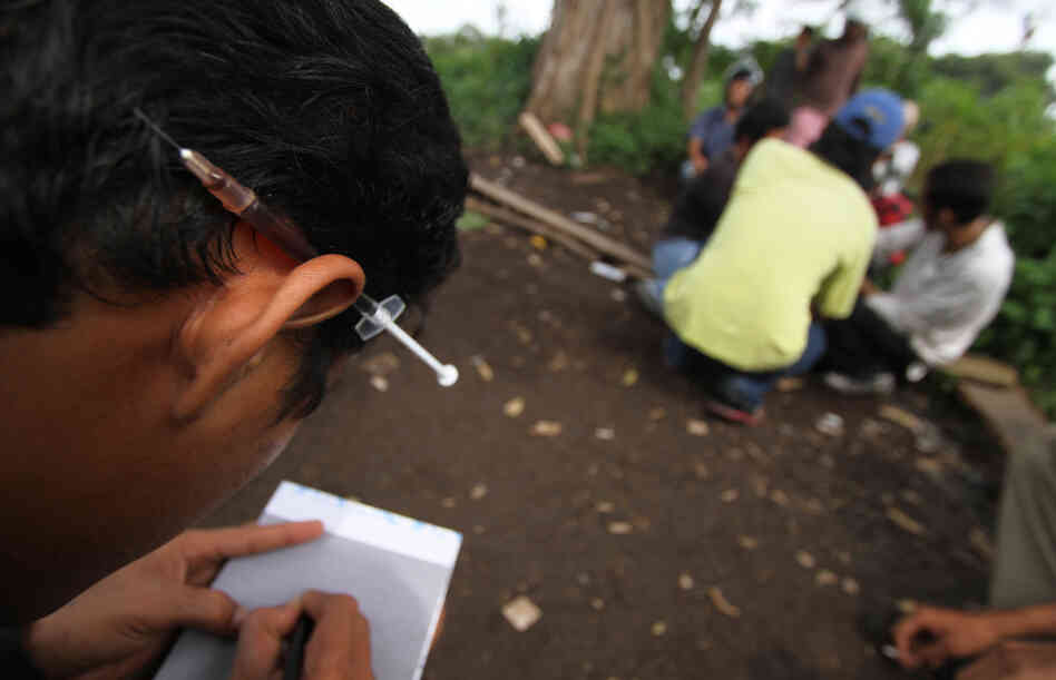 A heroin user keeps a syringe tucked behind his ear at a park in the city of Medan on Indonesia's Sumatra island. Cordita-Caritas Medan, a nongovernmental organization active there, works to reduce HIV infections through rehab of drug users and a needle exchange program.