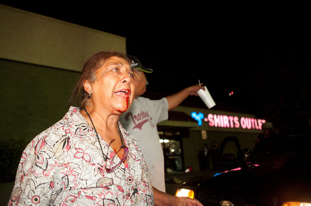 An injured pedestrian cries out to end the destruction of local properties after violence erupted between police officers and protesters during demonstrations to show outrage for the fatal shooting of Manuel Angel Diaz.