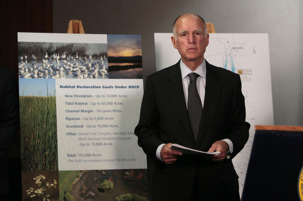 Gov. Jerry Brown waits for the start of a news conference to announce plans to build a giant twin tunnel system to move water from the Sacramento-San Joaquin River Delta to farmland and cities.