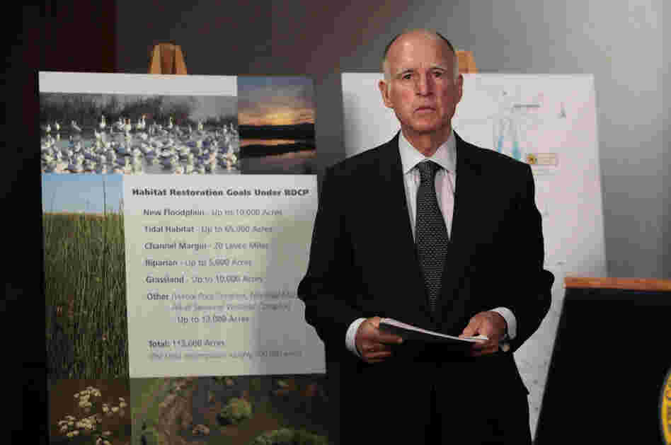Gov. Jerry Brown waits for the start of a news conference to announce plans to build a giant twin tunnel system to move water from the Sacramento-San Joaquin River Delta to farmland and cities.