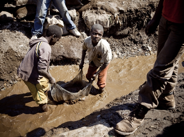 Children wash copper on July 9, 2010 at an open-air mine in Kamatanda in the rich mining province of Katanga, southeastern Democratic Republic of Congo (DRC). Forced by poverty, hundreds of students leave school to work at the mine.